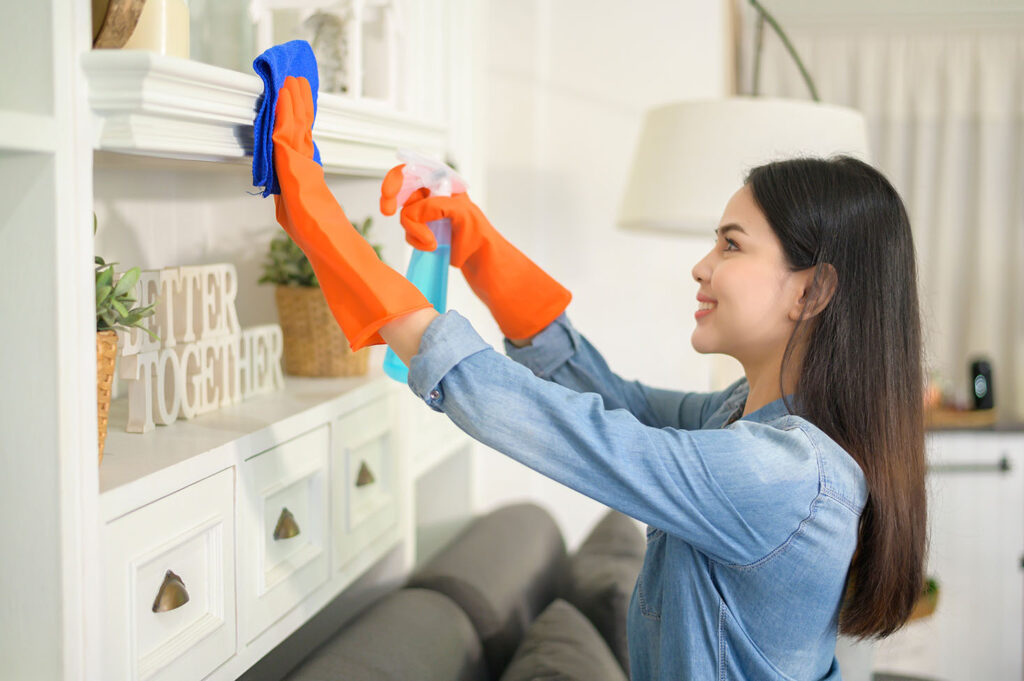Cleaner detailing bathroom tile, fixtures, and edges with organized supplies
