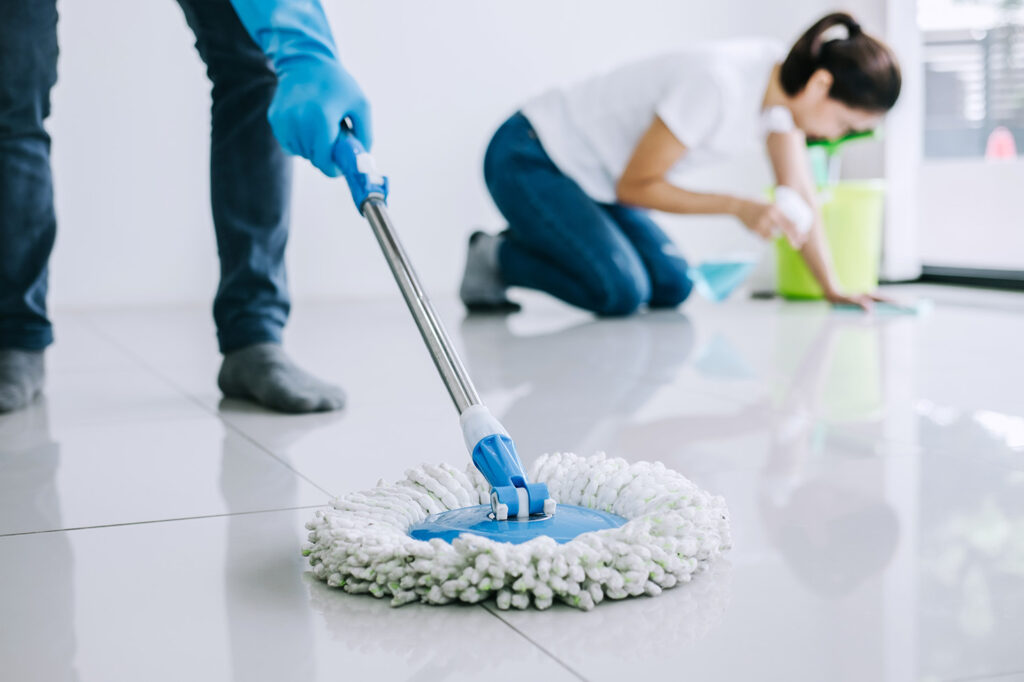 Cleaner scrubbing bathroom tile and vanity in occupied Las Vegas home