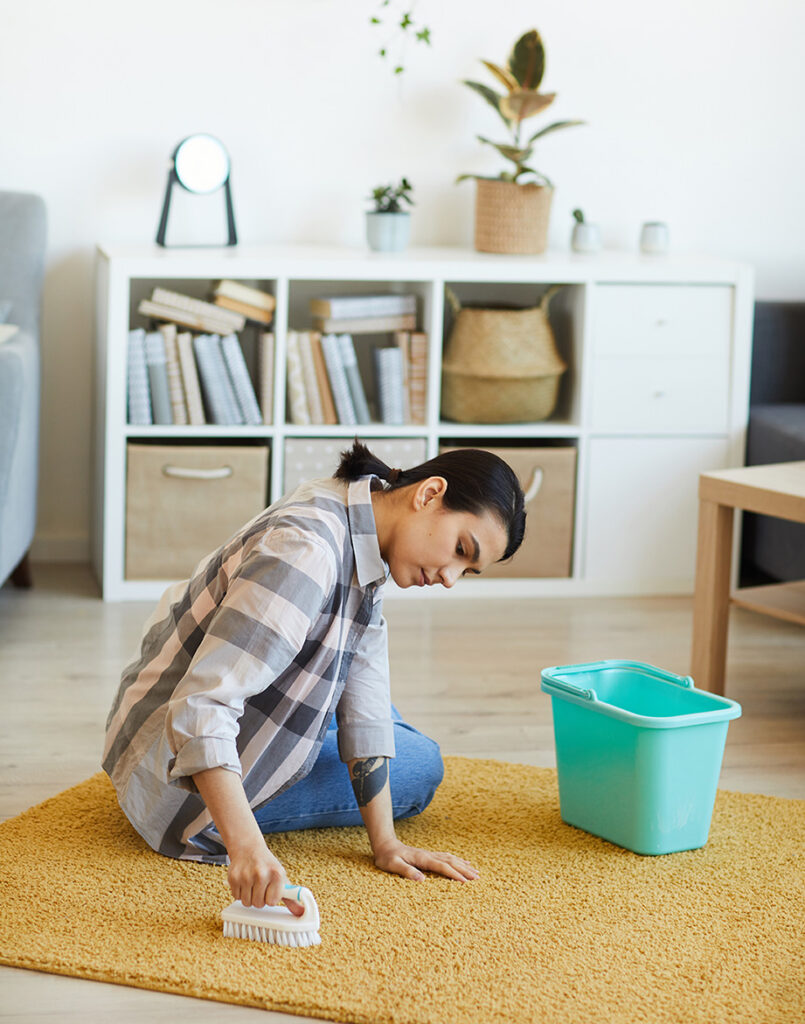House cleaner wiping kitchen counters and stove in busy Henderson family home