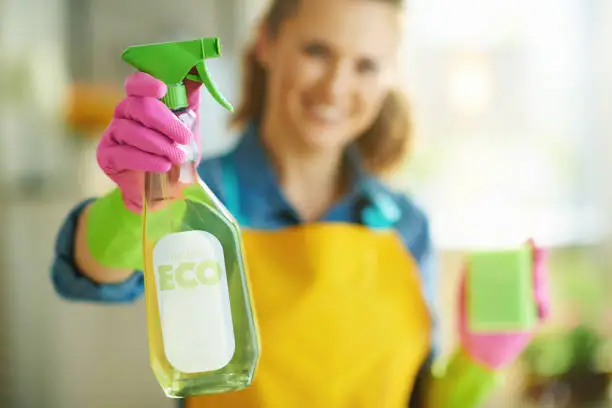Cleaner wiping kitchen counters with green products before family gathering in Las Vegas home